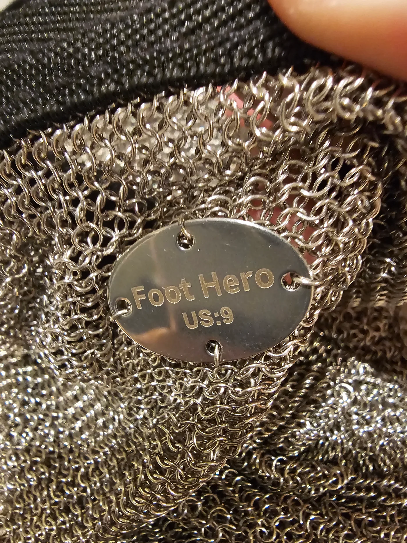 Close-up of the actual interlocking steel rings and Foot Hero metal tag